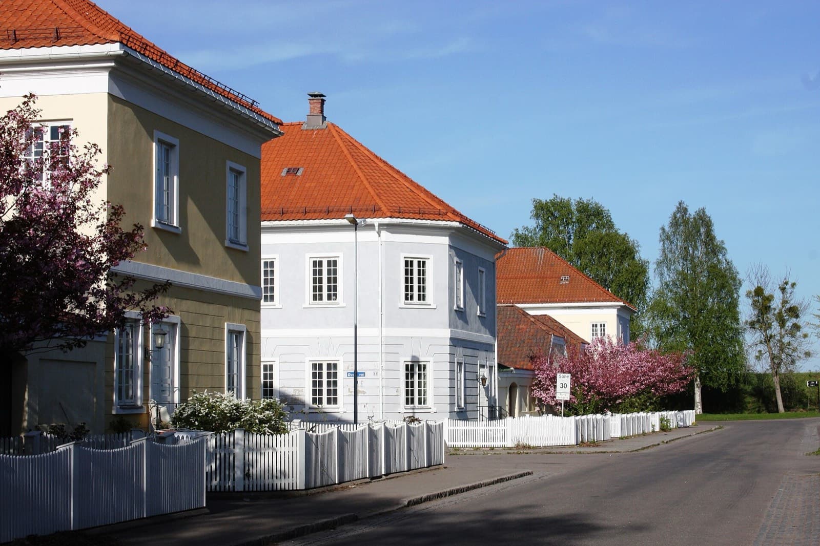 Gamle bygninger med teglrøde tak og blomstrende kirsebærtrær på Karljohansvern